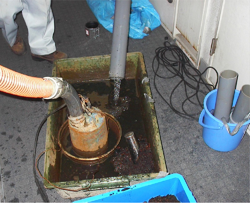 排水管の錆を回収している